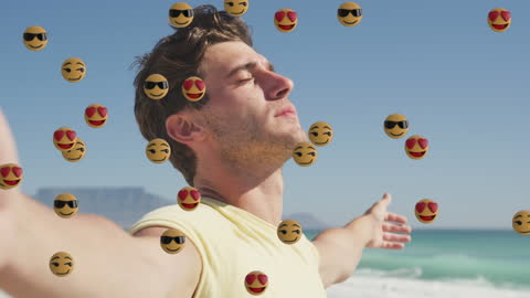 Man Enjoying Serenity at Beach Surrounded by Floating Emojis