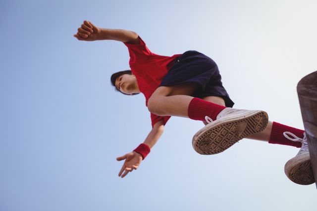 Boy jumping over obstacle during boot camp training. Ideal for use in articles or advertisements related to youth fitness, outdoor activities, sports training, and determination. Can also be used for motivational content or promoting athletic programs for children.
