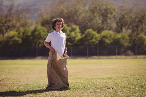 Energetic Schoolboy Enjoying Sack Race Outdoors
