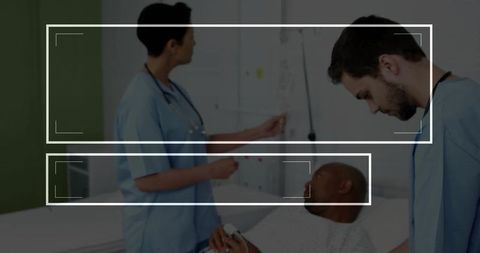 Medical staff checking patient monitors in hospital room