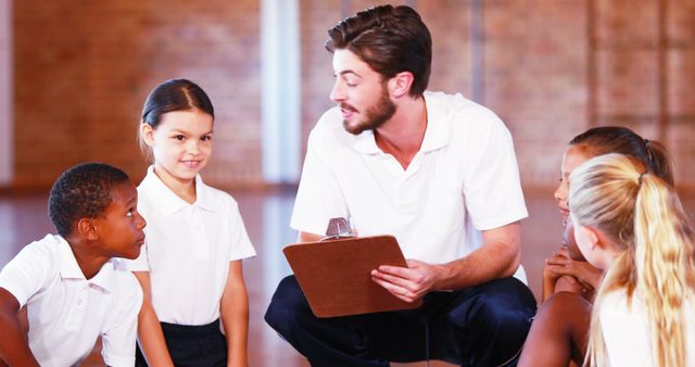 Male Coach Talking to Group of Diverse Children in Gymnasium - Download Free Stock Images Pikwizard.com