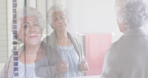 Senior Woman Reflecting in Mirror and Greeting Visitor