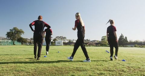 Female Athletes Practicing Cone Drills on Grassy Field