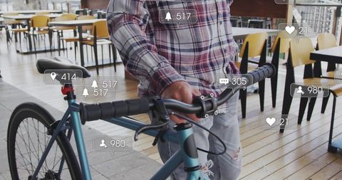 Urban cyclist holding teal bicycle in cafe with social media notifications, casual denim