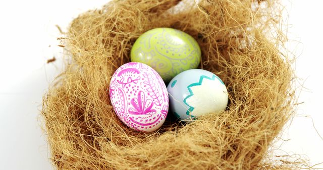 Colorful decorated Easter eggs are nestled in a natural twig nest. Great for holiday marketing, spring decorations, and festive greeting cards. Can be used for creating Easter-themed crafts, promoting seasonal products, and enhancing holiday-themed advertisements.