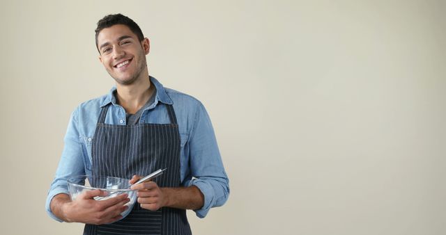 Smiling Young Man in Apron Mixing Ingredients in Kitchen - Download Free Stock Images Pikwizard.com