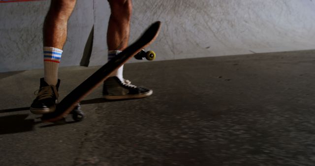 View of skateboarder balancing on a ramp in extreme sports park at night. Ideal for use in articles, blogs or advertisements focused on skateboarding, youth culture, extreme sports, urban activities, or nighttime events.