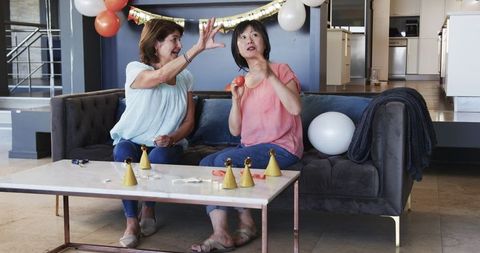 Multicultural senior friends preparing birthday with balloons