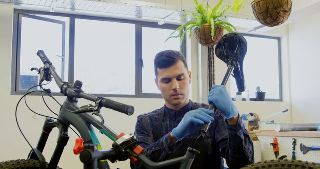 Male Bicycle Mechanic Adjusting Seat in Modern Workshop - Download Free Stock Images Pikwizard.com