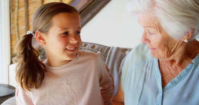 This image depicts a grandmother spending time with her granddaughter indoors. Great for illustrating themes of family, multigenerational relationships, affection, home life, and togetherness. Ideal for use in family-oriented articles, advertisements for family services, and caregiving resources.