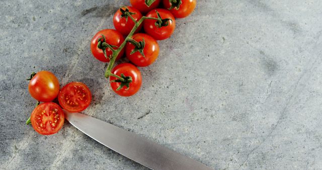 Fresh Cherry Tomatoes on Vine with Knife on Grey Stone Surface - Download Free Stock Images Pikwizard.com