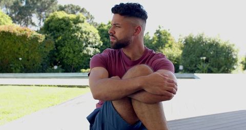 Hispanic Man Relaxing by Pool in a Tranquil Outdoor Setting