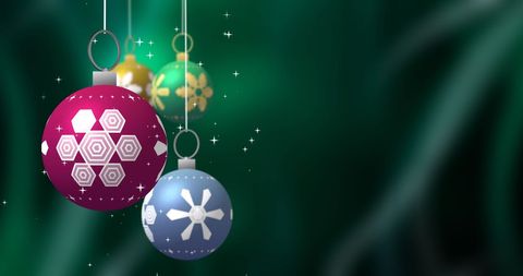Colorful Christmas Baubles with Sparkling Stars on Green Background