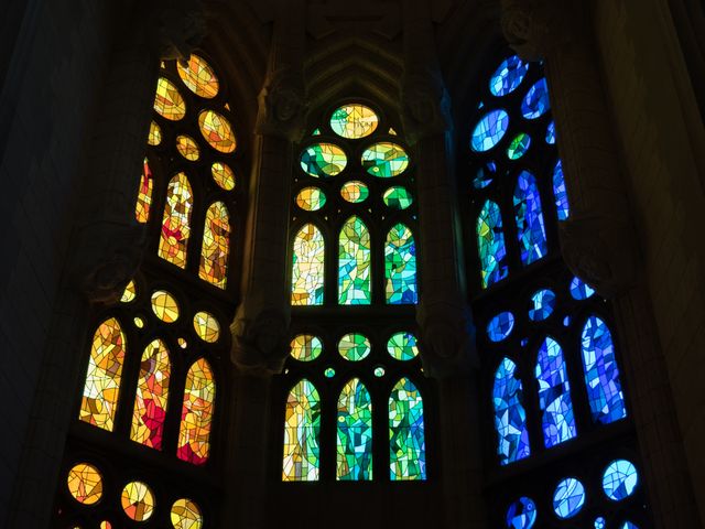 This image depicts vibrant stained glass windows in a cathedral, showcasing a spectrum of colors including yellow, green, and blue. Ideal for use in religious and spiritual contexts, architectural studies, or artistic design projects, it highlights the intersection of art and architecture in historic buildings. The image can be used for church brochures, travel guides, cultural education materials, and inspirational posters.