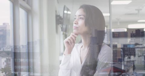 Pensive Businesswoman Overlooking Cityscape with Technology Overlay