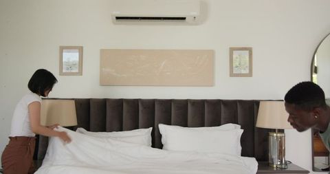 Couple Preparing Bed in Minimalist Bedroom Interior