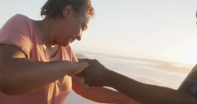 Smiling woman holding hands with a friend, enjoying a sunny day at the beach. This image captures the joy of friendship and the serene beauty of the seaside. Perfect for use in ads promoting friendship, leisure time, beach vacations, and emotional well-being.