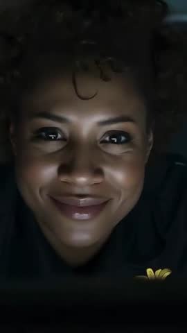 Smiling woman glowing under screen light, closeup vertical video showing warm expression