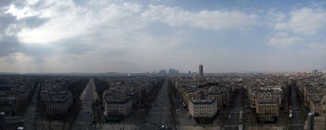 Features a wide panoramic view of Paris with prominent buildings and streets extending to the horizon under a cloudy sky. This image is great for showcasing travel, urban design, and architecture themes. It is suitable for use in travel blogs, destination marketing materials, and educational presentations about Paris.