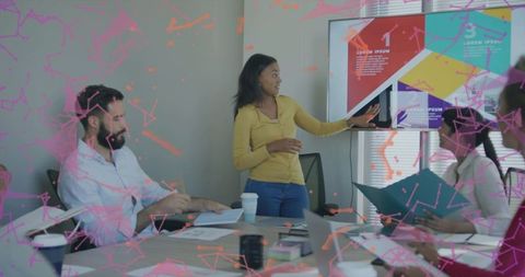 Collaborative team meeting presenting colorful slides in modern office boardroom