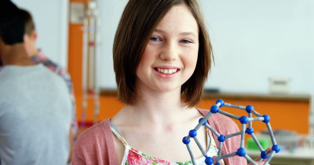 Smiling Girl Holding Geometric Model in Science Class - Download Free Stock Images Pikwizard.com