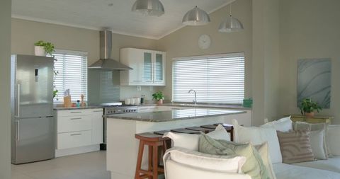 Neutral open-plan kitchen with marble island and three wooden stools, modern minimal
