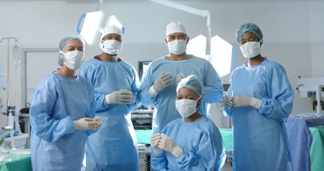 Portrait of diverse surgeons with face masks and medical gloves in operating room. Medicine, healthcare, surgery and hospital, unaltered.