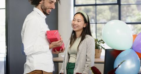 Colleagues Enjoying Office Celebration with Gift Exchange