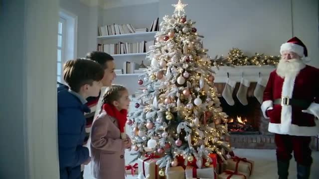 Siblings Discovering Santa by Decorated Christmas Tree