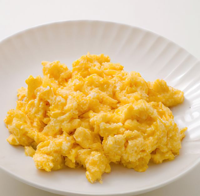 Bright and delicious scrambled eggs served on a white plate, showcasing the simplicity and appeal of a classic breakfast dish. Suitable for use in culinary magazines, cooking blogs, health and nutrition articles, or restaurant menus, emphasizing nutritious and easy-to-make breakfast options.
