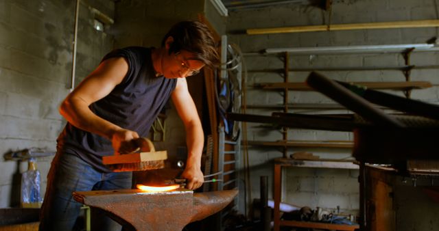 Male Blacksmith Forging Metal in Dimly Lit Workshop - Download Free Stock Images Pikwizard.com