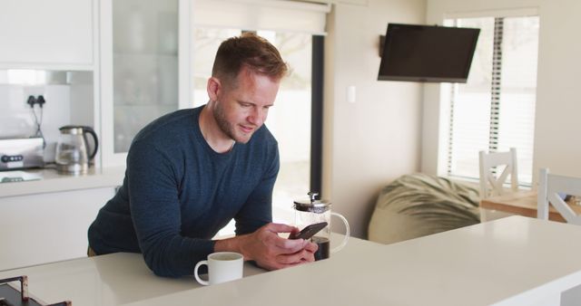 Man Reading Smartphone Notifications in Modern Kitchen - Download Free Stock Images Pikwizard.com