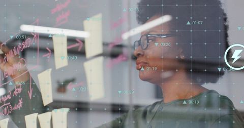 Businesswoman Analyzing Data on Transparent Board