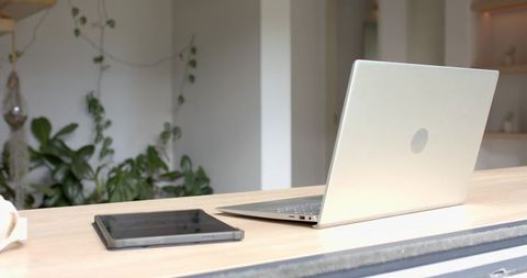 Minimalist Workspace with Silver Laptop and Tablet on Sleek Wooden Desk
