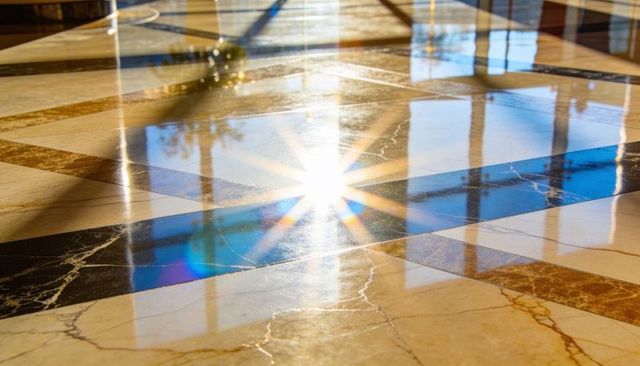 Sunburst reflecting on polished marble floor with prismatic flare and geometric tiles