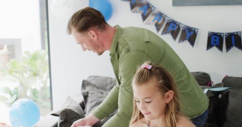 Family Cleaning Up After Birthday Celebration with Balloons