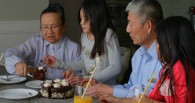 Front view of old senior asian grandmother serving birthday cake in a comfortable home. Multi-generation asian family celebrating granddaughters birthday 4k