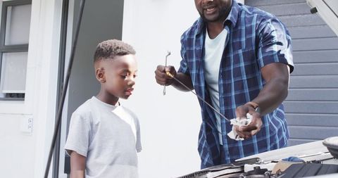 Father teaching son car maintenance for a bonding experience