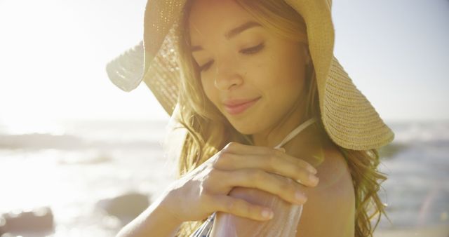 Smiling woman applying sunscreen at sunny beach - Download Free Stock Images Pikwizard.com