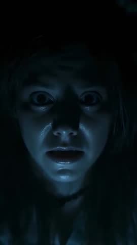 Underlit Woman Holding Fixed Gaze in Dark Blue Closeup Vertical Video for Thriller