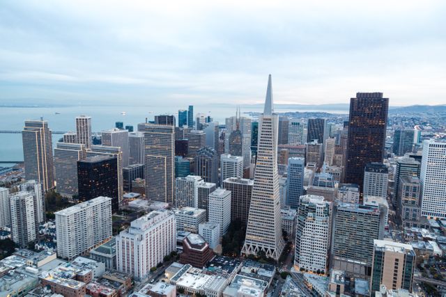 Aerial view capturing San Francisco downtown's iconic skyline during dusk. Suitable for real estate content, travel blogs, city guides, and presentations highlighting urban development or business environments.
