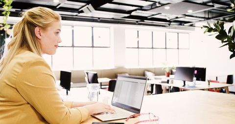 Businesswoman Working on Laptop in Modern Casual Office Interior