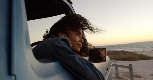 Young woman enjoying beach view from car window at sunset - Download Free Stock Images Pikwizard.com