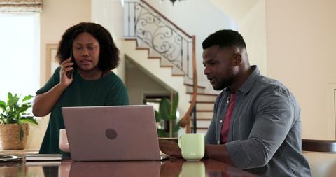 Couple Collaborating at Home Using Laptop and Coffee for Modern Life Planning