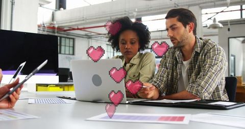 Colleagues collaborating in modern office with love emoji overlay