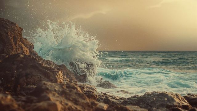 Vibrant Ocean Waves Crashing on Rocky Coastline at Sunset