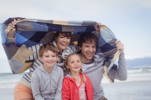 Portrait of happy family at beach during winter