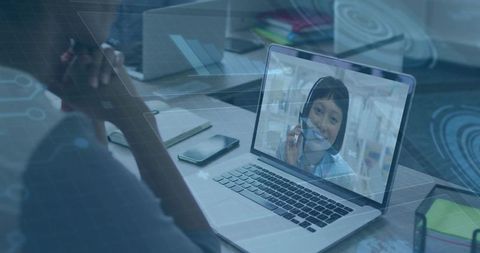 Video call on laptop with smartphone and digital circuit overlay for remote collaboration
