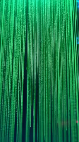 Vertical video of cascading green data strands pulsing with luminescent digital motion