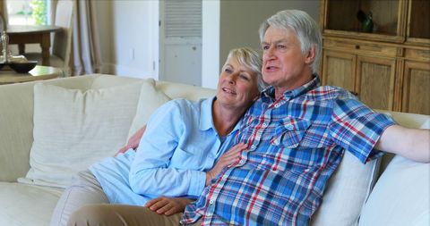 Senior Couple Relaxing on Sofa in Cozy Living Room